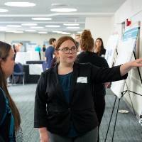 Scholar giving poster presentation to a student.